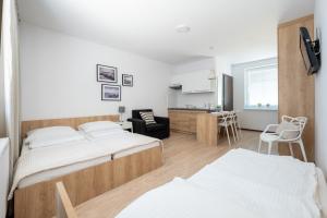 a bedroom with a bed and a living room at Pokoje blisko morza Przy Porcie in Darłowo
