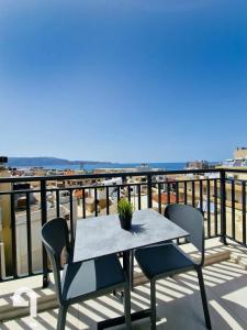 a table and chairs on a balcony with the ocean at Arsinois Residence in Heraklio Town +134 photos