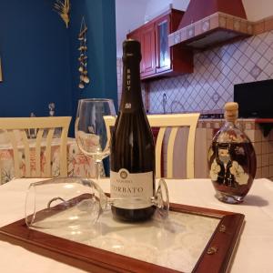 a bottle of wine sitting on a table with glasses at Casa Vacanze Eloise in Quartu SantʼElena +17 photos