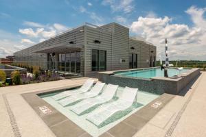 a building with a swimming pool and white lounge chairs at Clarendon 1BR w Gym WD Pool nr Metro WDC-381 in Arlington
