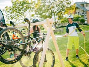 a man is washing a bike with a hose at Holiday home in Faak am See in Faak am See
