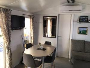 a living room with a table and a couch at Mobilhome au bord de mer in Piriac-sur-Mer