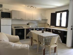 a kitchen with a table and chairs and a kitchen with a table and a couch at Mimi Leuca B&b in Leuca