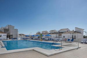 een zwembad bij een hotel met stoelen en parasols bij Loft Marina in Vejer de la Frontera