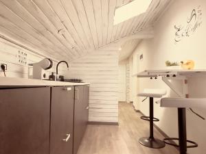 a kitchen with a counter and stools in a room at G-house in Parma +15 photos