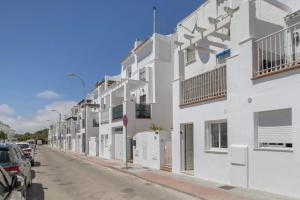 een rij witte appartementsgebouwen in een straat bij Loft Marina in Vejer de la Frontera