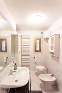 a white bathroom with a sink and a toilet at Casetta nel bosco di Valeria e Davide in Rocca Priora +20 photos