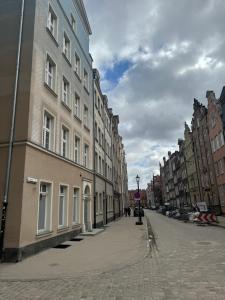 an empty city street with buildings on a cloudy day at Ogarna 33 studios in Gdańsk