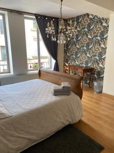 sypialnia z dużym łóżkiem i żyrandolem w obiekcie La Chambre d'Angèle w mieście Sedan
