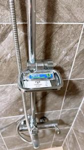 a metal toothbrush holder on a tile wall at Garden in Jeju 201 in Seogwipo +289 photos