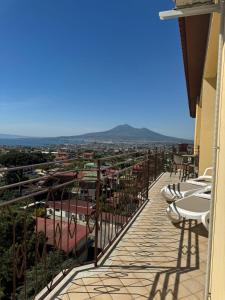 a balcony with tables and chairs overlooking a city at Blue House GM in Gragnano