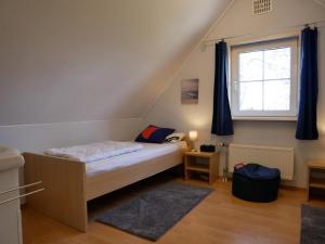 Un dormitorio pequeño con una cama y una ventana. en Villa Lachmöwe, en Sint Maartensvlotbrug