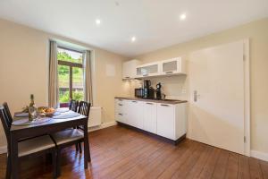 een keuken en eetkamer met een tafel en een eetkamer gmaxwell gmaxwell bij Alte Stadtvilla Weinberg 5 in Traben-Trarbach