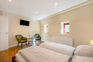 een slaapkamer met twee bedden en twee stoelen bij Alte Stadtvilla Weinberg 5 in Traben-Trarbach