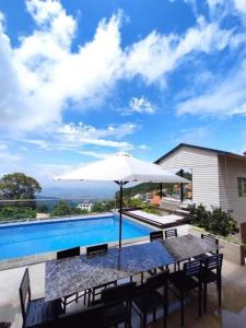 a table with an umbrella next to a swimming pool at Bich Ngoc Villa - Venuestay in Tam Ðảo