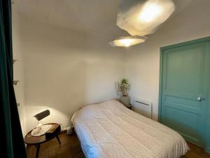a bedroom with a bed and a table with a lamp at Maison de village a la Turbie in La Turbie