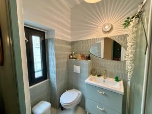 a bathroom with a sink and a toilet and a mirror at Maison de village a la Turbie in La Turbie