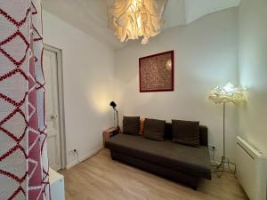 a living room with a couch and a lamp at Maison de village a la Turbie in La Turbie