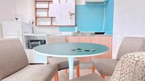 a table in a kitchen with chairs and a sink at Garden in Jeju 201 in Seogwipo