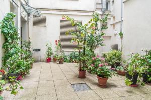 a courtyard with potted plants on the side of a building at Apart Merryland Paris Châtelet in Paris