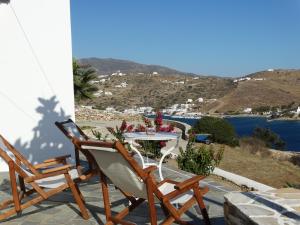 a patio with two chairs and a table with flowers at Gaia house, Ios Greece in Tzamaria