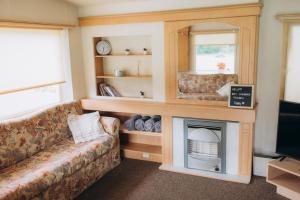 a living room with a couch and a fireplace at Atvases in Pērkone +44 photos