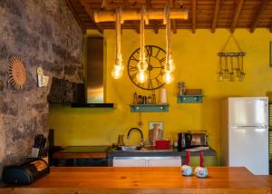 een keuken met gele muren en een houten tafel bij Quinta Morazes Casas de Campo in Ribeira Grande