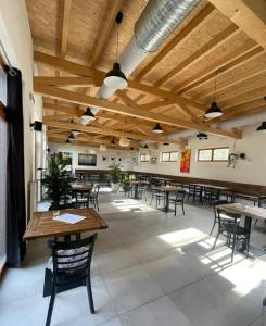 a large room with tables and chairs and wooden ceilings at Tetris domky v Beachklubu Ládví in Prague