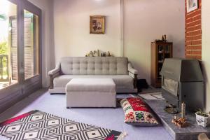 a living room with a couch and a tv at Vikendica Solitudo House Tuzla in Crno Blato