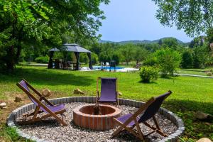 two chairs and a fire pit in a yard at Vikendica Solitudo House Tuzla in Crno Blato