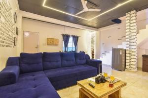 a living room with a blue couch and a table at Black Stone Villa in Lonavala