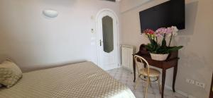 a bedroom with a bed and a table with flowers on it at Albergo La Conca Azzurra in Conca dei Marini