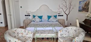 a bedroom with a bed and two chairs at Albergo La Conca Azzurra in Conca dei Marini