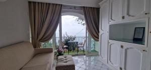 a living room with a couch and a balcony at Albergo La Conca Azzurra in Conca dei Marini