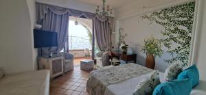 a bedroom with a bed and a couch and a window at Albergo La Conca Azzurra in Conca dei Marini