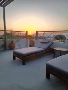 two beds on a balcony with the sunset in the background at Marias Guest House in Zipárion