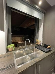a kitchen counter with a sink and a mirror at Marias Guest House in Zipárion +29 photos