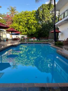 a large blue pool with trees in the background at Hotel Totara in Dar es Salaam