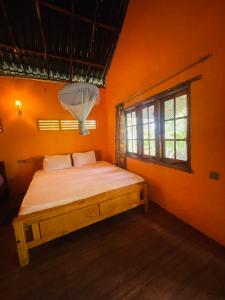 a bedroom with a bed in an orange room at LakeSide Cabana Tissamaharama in Tissamaharama