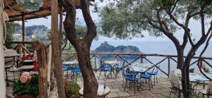 a patio with tables and chairs and a view of the ocean at Albergo La Conca Azzurra in Conca dei Marini