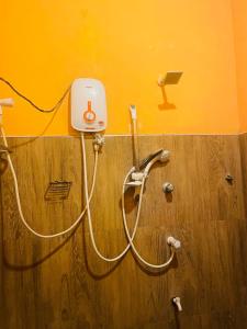 a wall with a hose hooked up to a outlet at LakeSide Cabana Tissamaharama in Tissamaharama