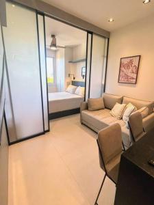 Una sala de estar con un sofá y un dormitorio. en Beachfront Studio,, en Río de Janeiro