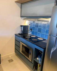 cocina con fogones y pared de azulejos azules en Beachfront Studio,, en Río de Janeiro