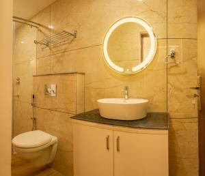 ein Badezimmer mit Waschbecken, Toilette und Spiegel in der Unterkunft Udaya Hills Cottages in Vagamon + 79 Fotos