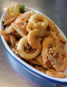 a bowl of shrimp with a lemon on a table at Albergo La Conca Azzurra in Conca dei Marini