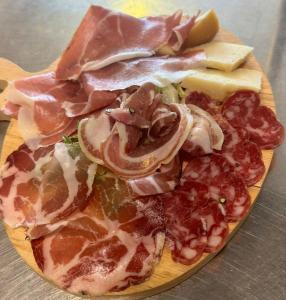 a plate of food with meats and cheese on a table at Albergo La Conca Azzurra in Conca dei Marini