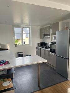 a kitchen with a table and a refrigerator at Plouha sur Mer in Plouha