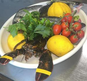 a plate of vegetables and fruit on a table at Albergo La Conca Azzurra in Conca dei Marini