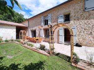 a garden with an archway in front of a building at Maison de campagne Gite Les Agates in Camiran