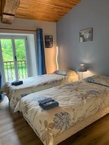 a bedroom with two beds and a window at Maison de campagne Gite Les Agates in Camiran